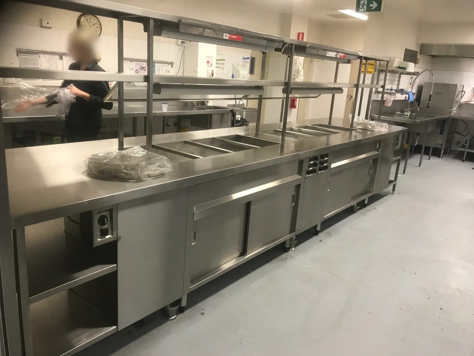 Hot food servery with bain marie wells, heat lamps and heated cabinets