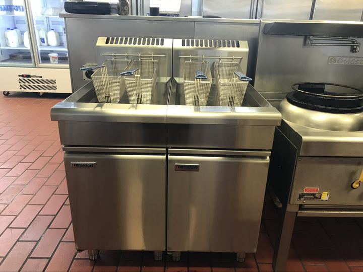 Waldorf twin gas fryers beside Goldstein wok